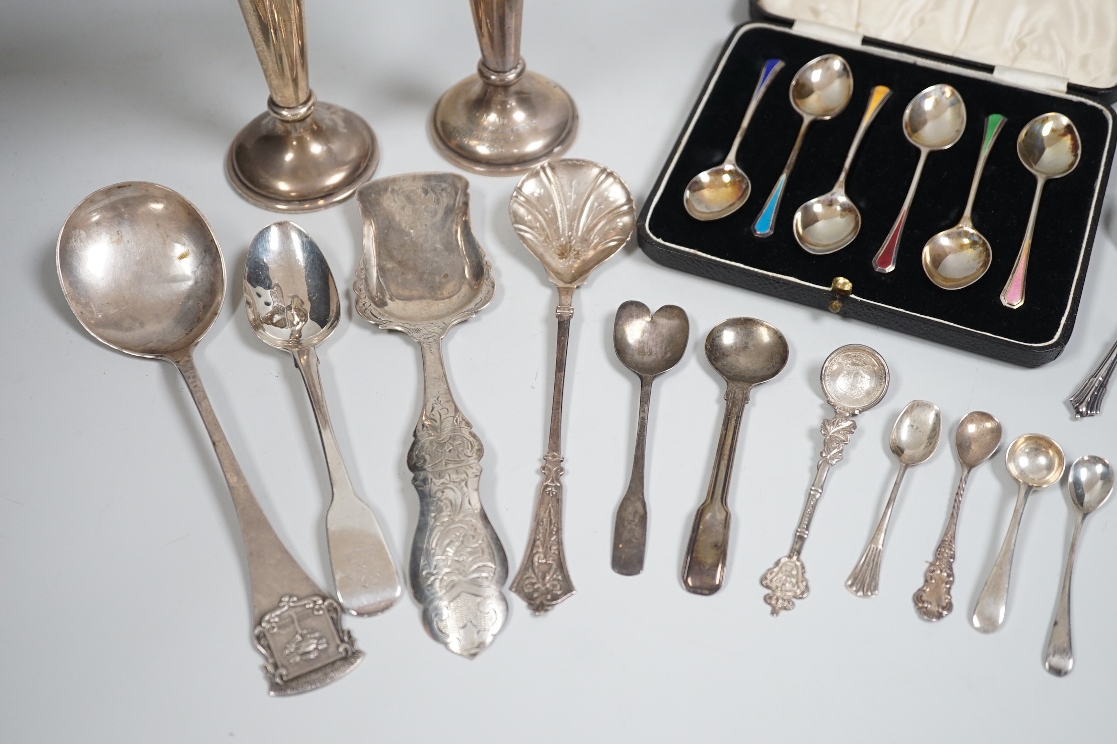 A cased set of six Edwardian silver and enamel teaspoons, William Hair Haseler, Birmingham,1913 and a collection of silver spoons and two silver mounted specimen vases.